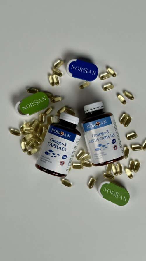 Picture is depicing Total and Arktis bottles flat with travel pill-boxes and omega3 capsules