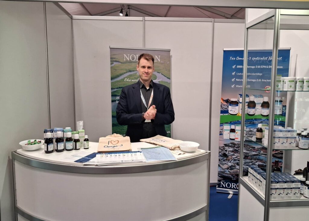 Norsan employee, smiling and offering help in an event